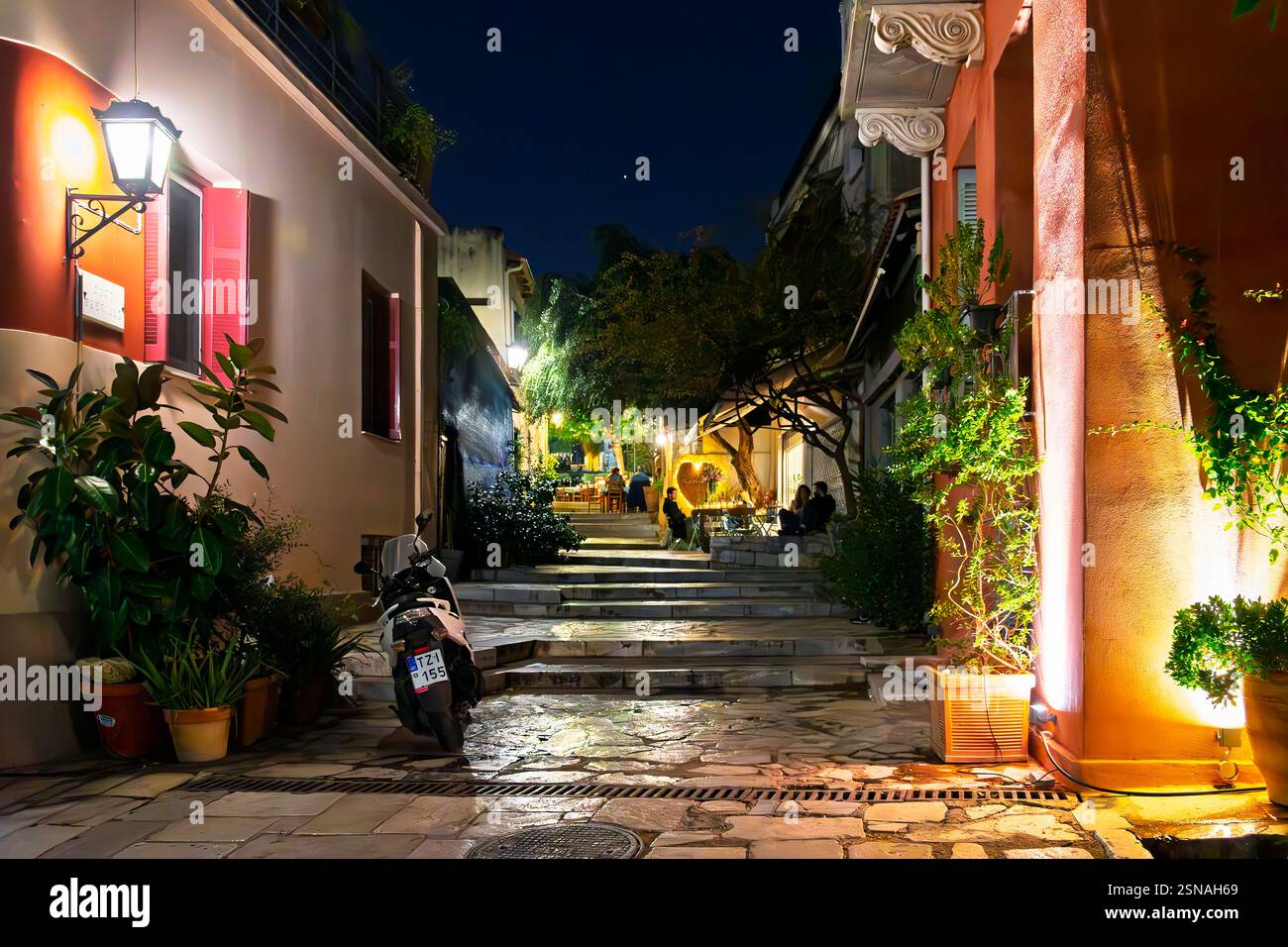 Ein Straßencafé und Restaurant in einer bunten Gasse bei Nacht im historischen Plaka-Viertel unter der akropolis in Athen, Griechenland. Stockfoto