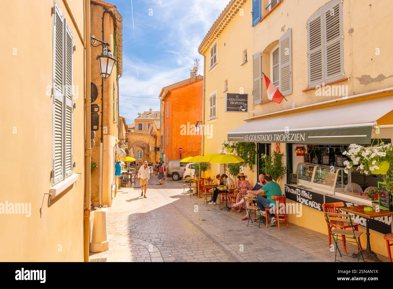 Eine malerische Straße mit Geschäften und Straßencafés in der historischen Altstadt von St. Tropez, an der französischen Riviera, Cote d'Azur. Stockfoto