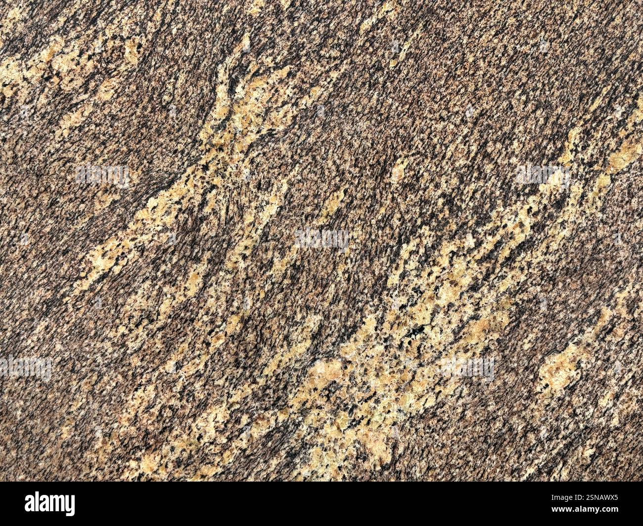 Nahaufnahme von zufälligem braunem Marmor mit schwarzen und beigefarbenen Adern diagonal. Natürliche Marmor- oder Granitsteinstruktur mit schwarzen Körnern. Nahtloser Hintergrund Stockfoto