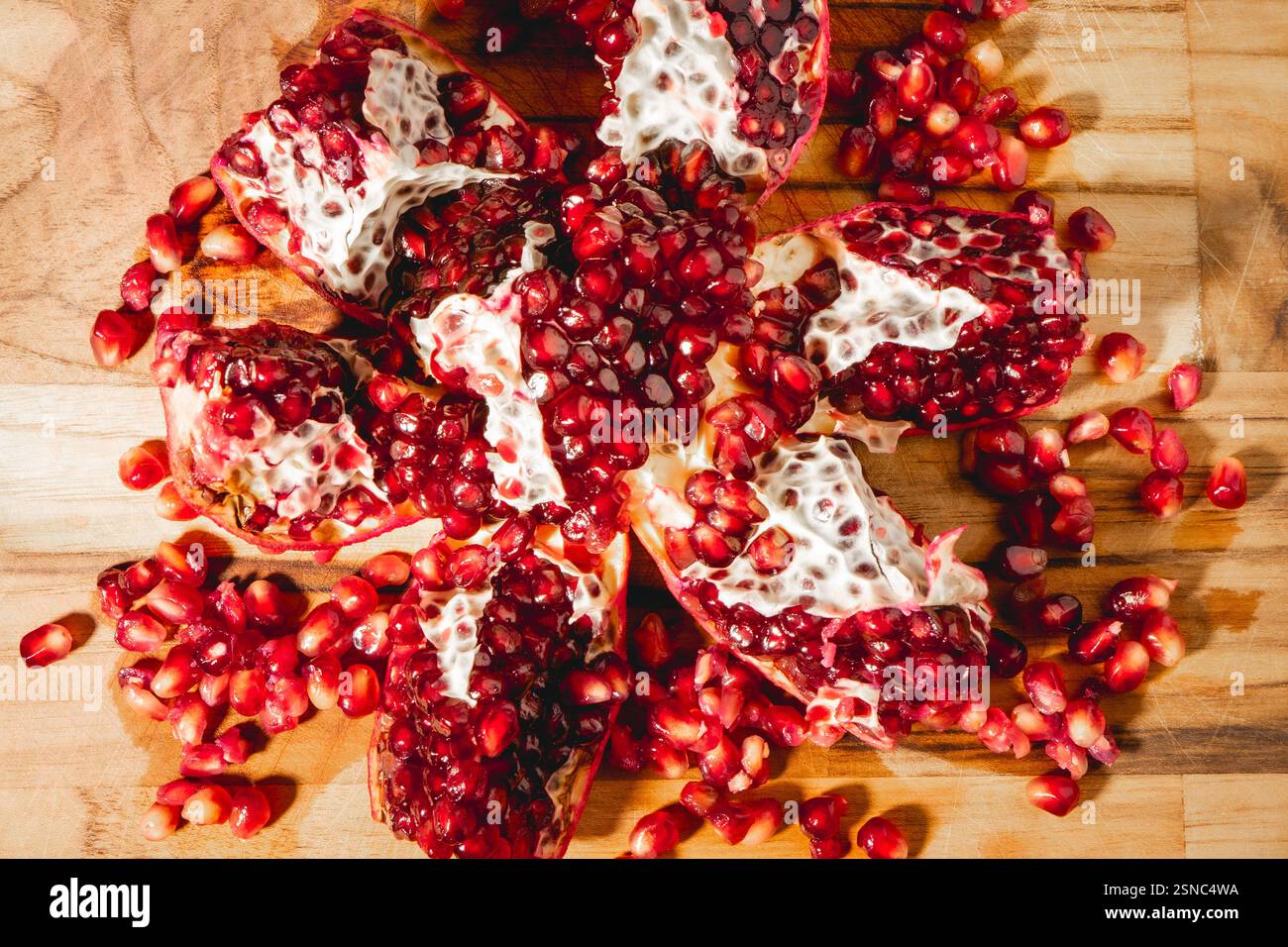 Eine offene Pomegranade auf hölzernem Hintergrund. Stockfoto