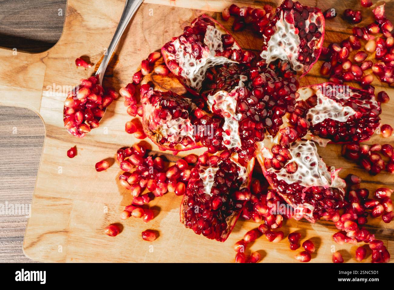 Eine offene Pomegranade auf hölzernem Hintergrund. Stockfoto