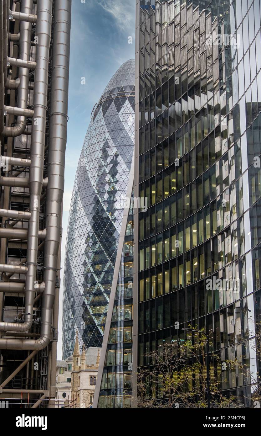 Moderne architektonische Meisterwerke im Londoner Finanzviertel – das ikonische Gherkin Building, eingerahmt von Lloyd’s of London und Wolkenkratzern, zeigt Urb Stockfoto