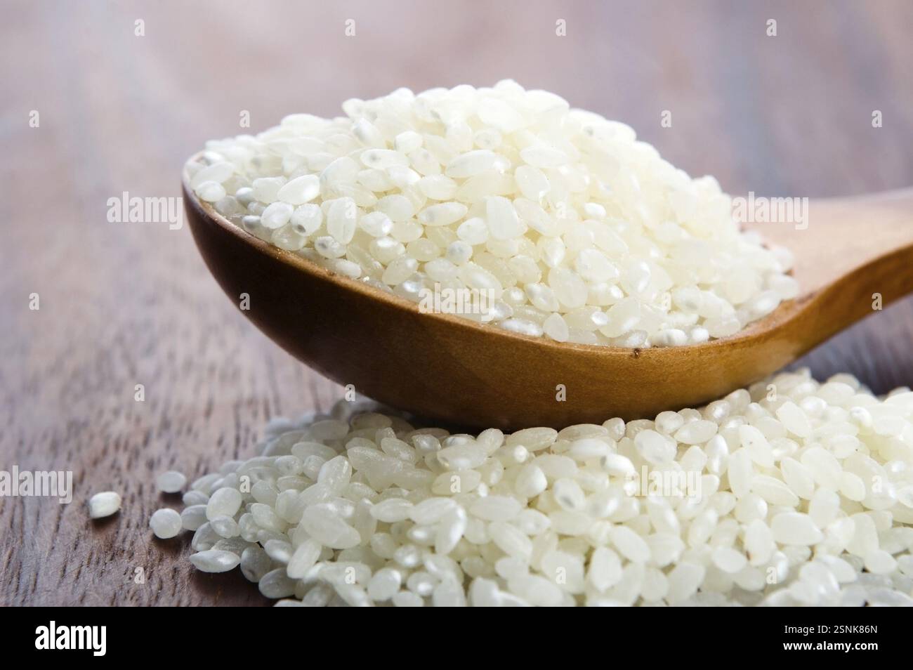 Reis im Holzlöffel auf dem Küchentisch, lodz Stockfoto