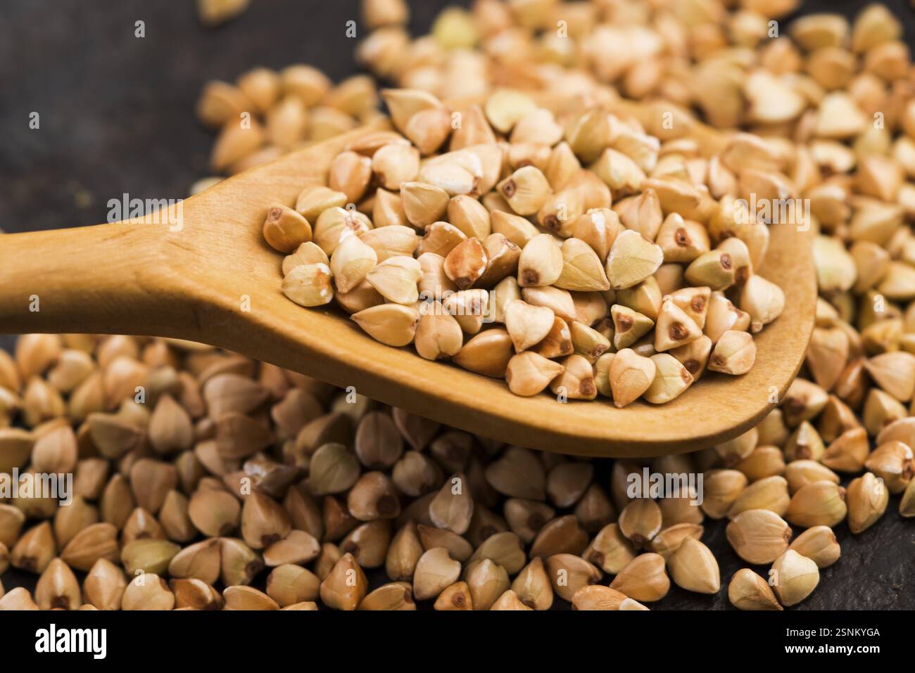 Buchweizen mit einem Löffel auf einem Holzbrett Hintergrund Stockfoto