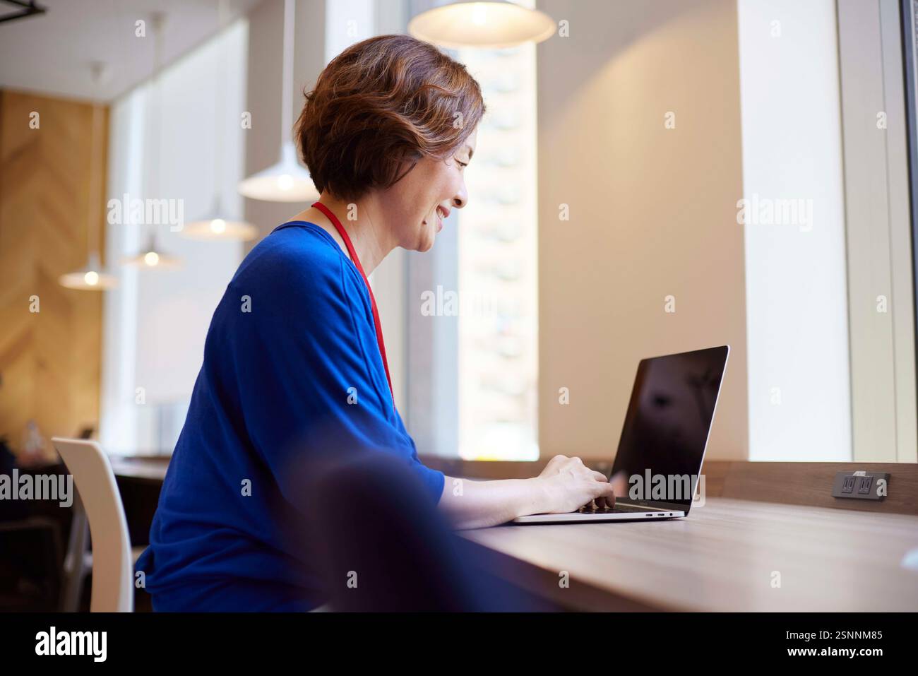 Japanische Geschäftsfrau, die in ihrem Büro mit einem Laptop arbeitet Stockfoto