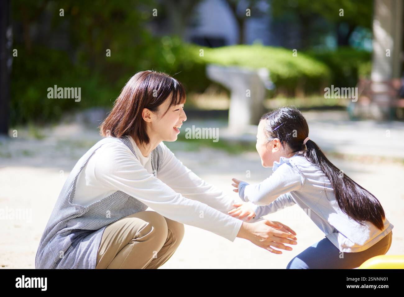 Lächelnde Kinderbetreuerin, die ein Kind umarmt Stockfoto