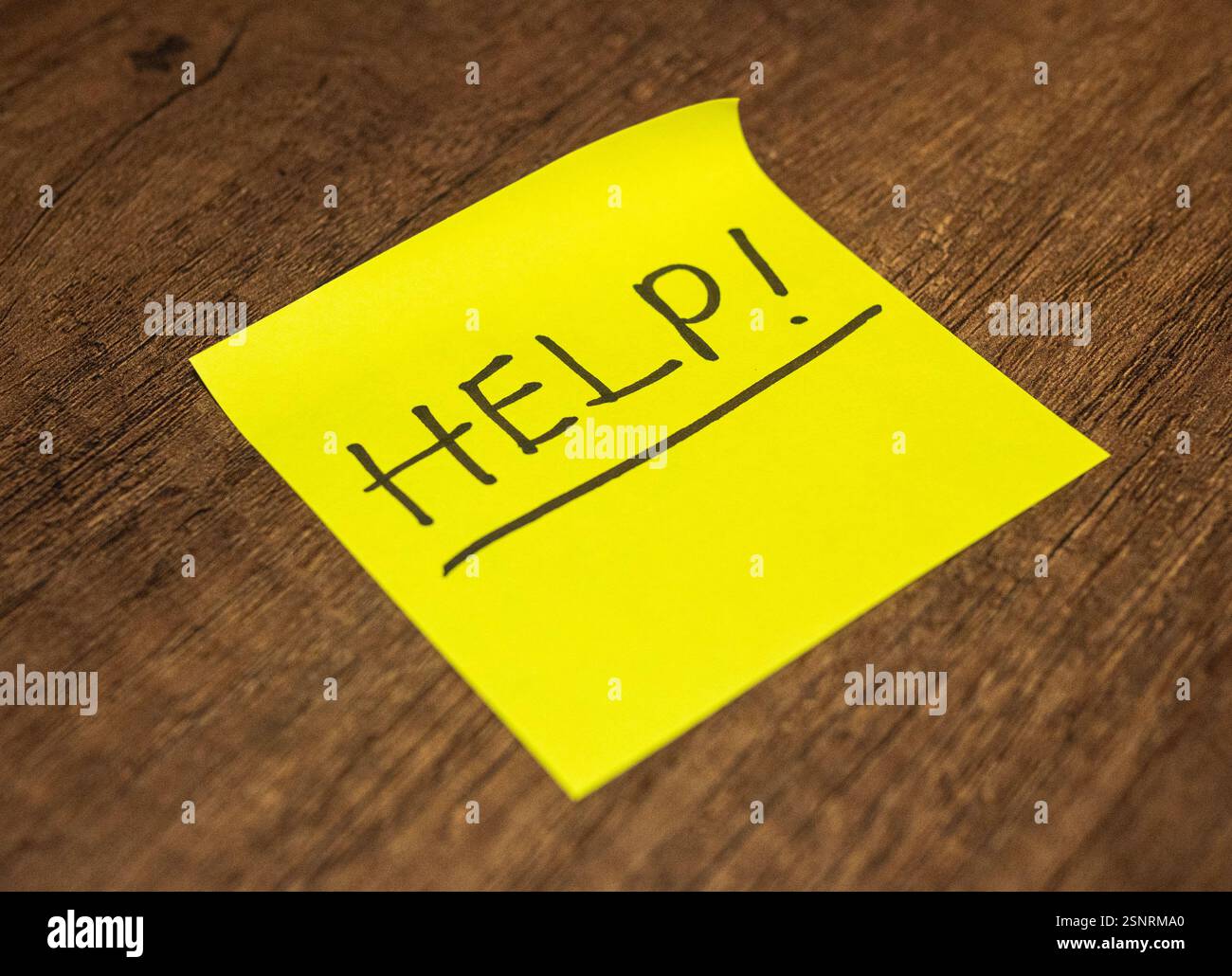 Hellgelbe Haftnotiz auf einer Holzoberfläche Stockfoto