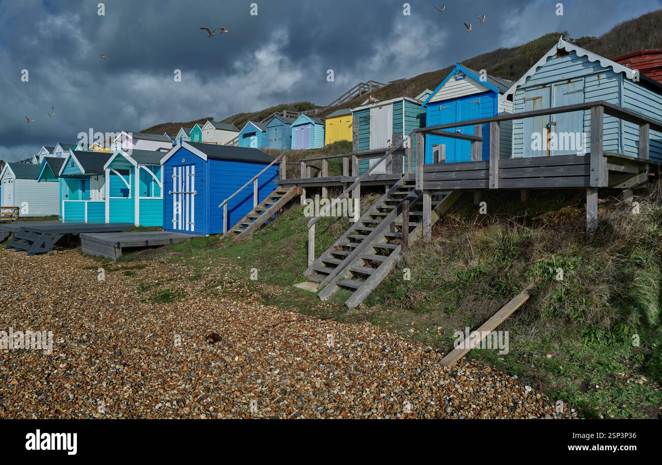 Traditionelle hölzerne, bunt bemalte Strandhütten am Kiesstrand von Milford on Sea, Hampshire Engalnd, Großbritannien Stockfoto