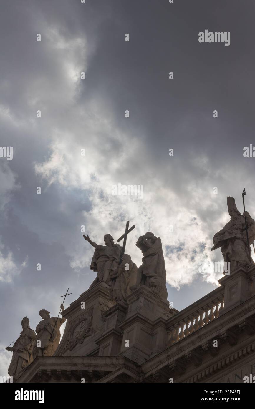 Historische Steinstatuen auf einem architektonischen Gebäude mit bewölktem Himmel symbolisieren Geschichte und Kultur. Stockfoto