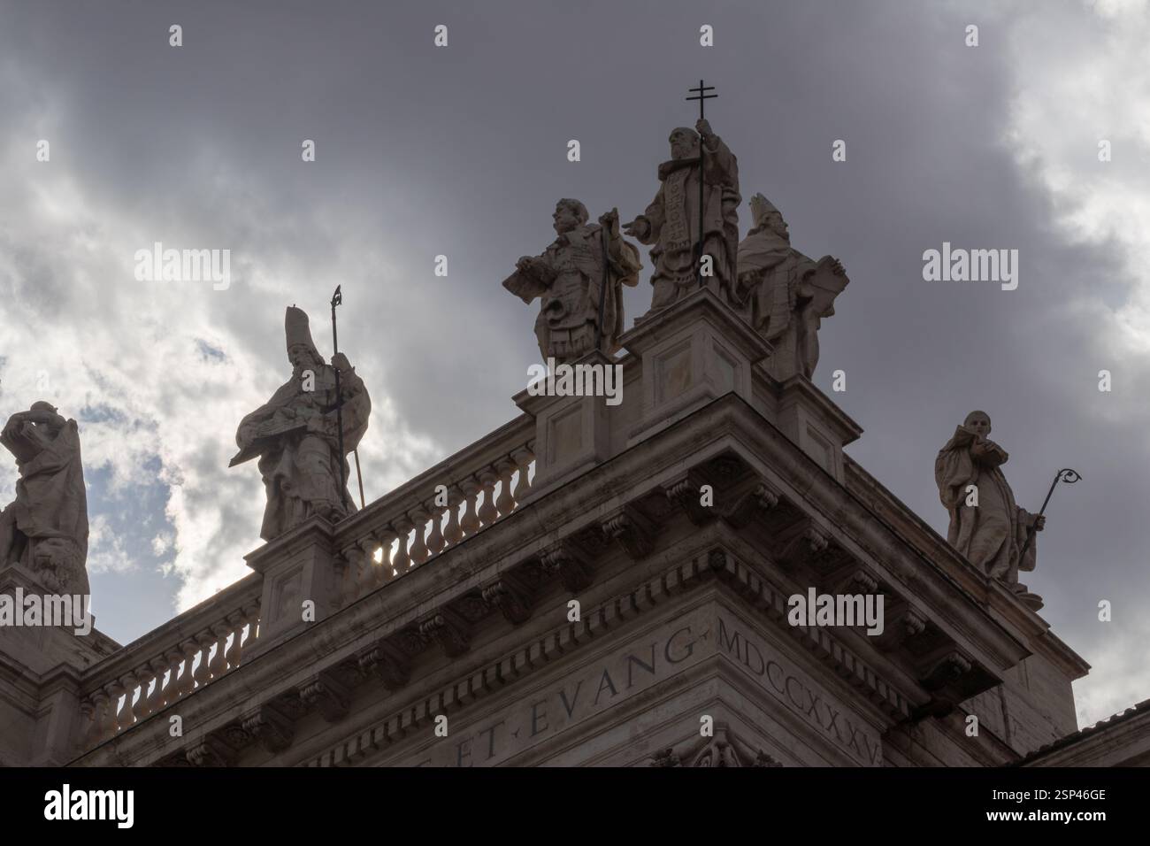 Historische Steinstatuen auf einem architektonischen Gebäude mit bewölktem Himmel symbolisieren Geschichte und Kultur. Stockfoto