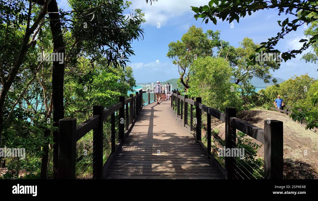 Eine Gruppe steht auf einer hölzernen Brücke im Noosa National Park und genießt an einem sonnigen Tag einen Blick auf das Meer – ein malerischer Aussichtspunkt, der auch Freunde genießen kann Stockfoto