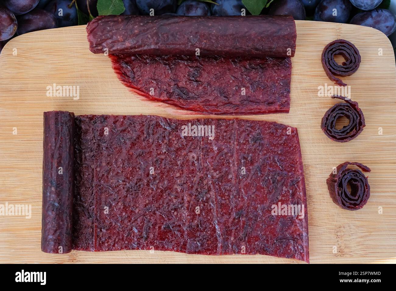 Obstleder und Brötchen. Hausgemachte oder handgemachte Pastille auf dem Holzbrett. Stockfoto