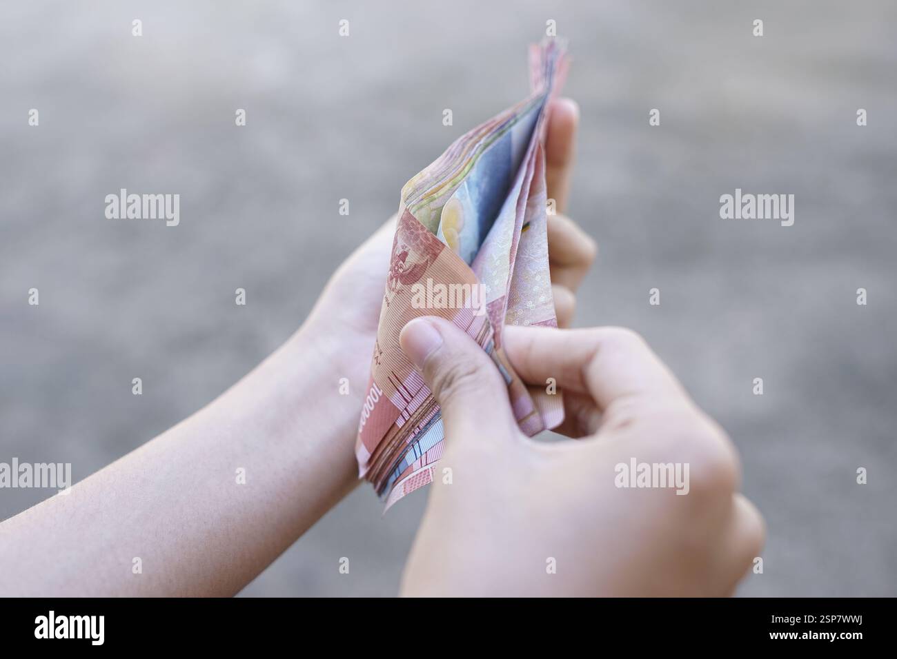 Die Menschen zeigen indonesisches Geld als legales Zahlungsinstrument Stockfoto