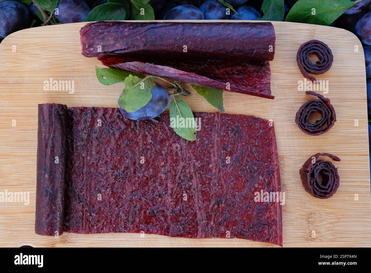 Obstleder und Brötchen. Hausgemachte oder handgemachte Pastille auf dem Holzbrett. Stockfoto