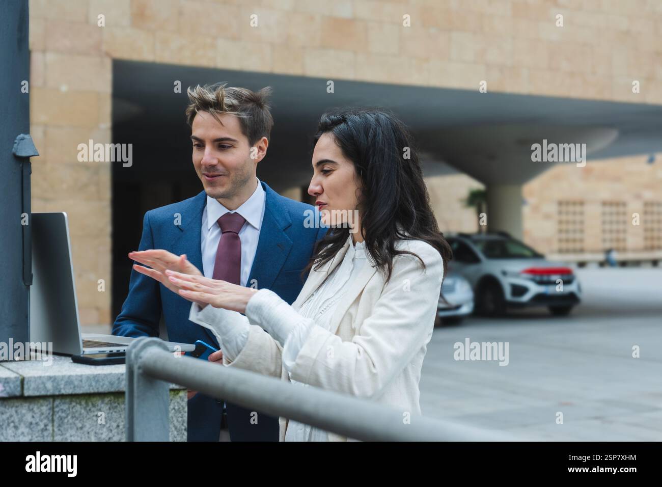 Geschäftsleute, die draußen in der Stadt an einem Laptop arbeiten Stockfoto