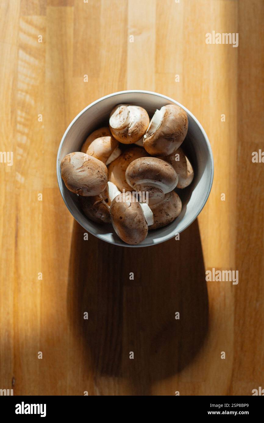 Schüssel mit Cremini-Pilzen auf Holzoberfläche Stockfoto