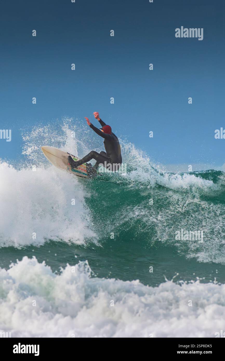 Ein Surfer auf einer Welle im Fistral in Newquay in Cornwall in Großbritannien. Stockfoto