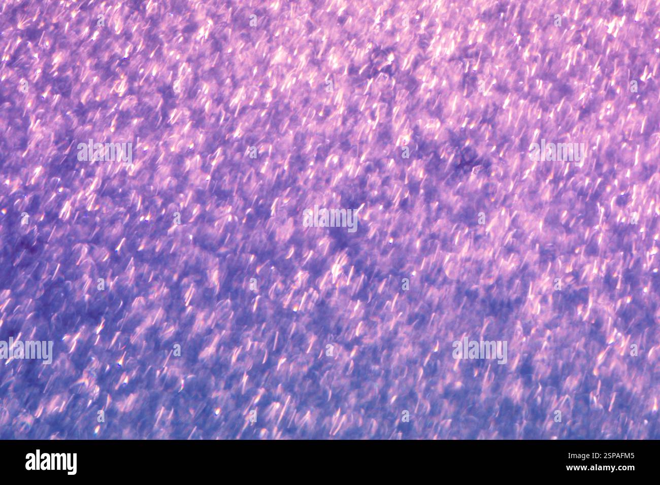 Blau-violetter Glitzer abstrakter Hintergrund von verschwommenen glänzenden Lichtern Stockfoto