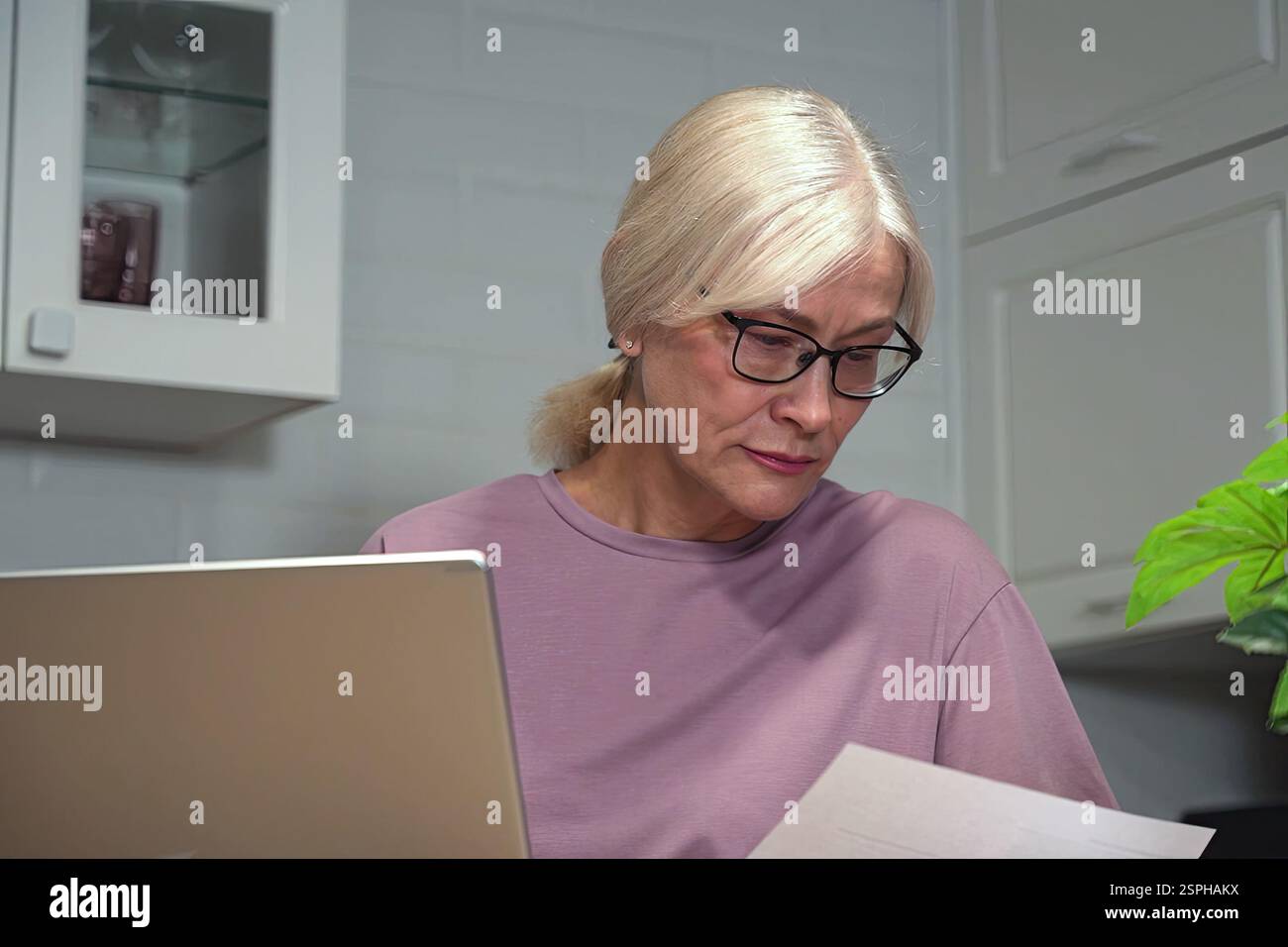 Frau, die Dokumente zu Hause überprüft Stockfoto