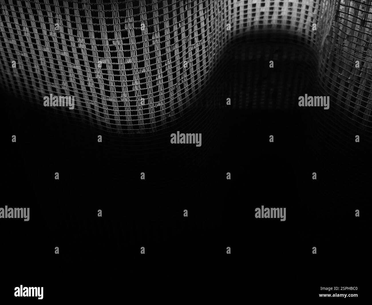 Geschwungene Schatten – sonnendurchflutete Vorhänge in der Dunkelheit Stockfoto