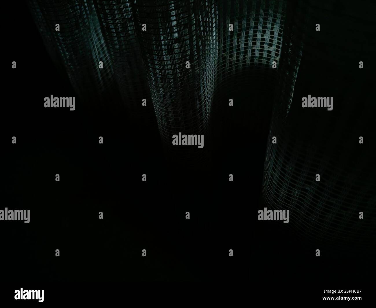 Geschwungene Schatten – sonnendurchflutete Vorhänge in der Dunkelheit Stockfoto