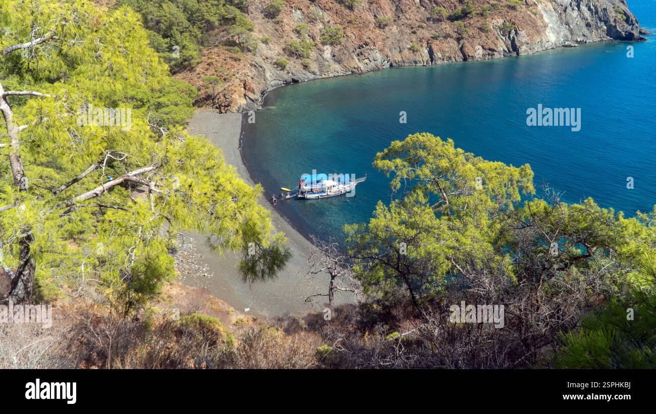 Antalya, Türkei - 5. Oktober 2024: Ein Segelboot an der atemberaubenden türkischen Mittelmeerküste in Antalya. Blaues Meer, umgeben von üppig grünen Wäldern und Teppichen Stockfoto
