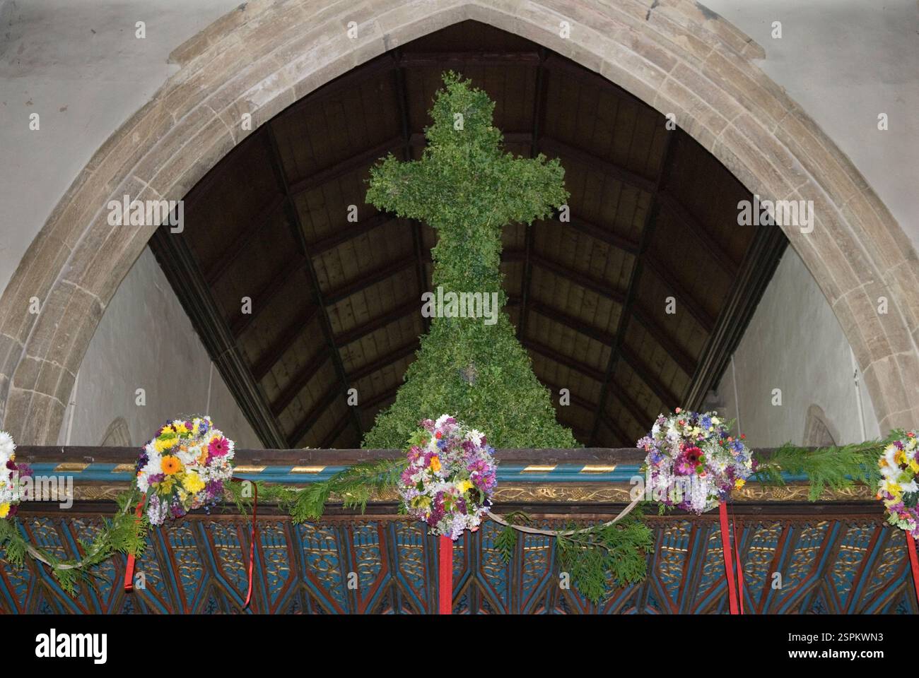Charlton-on-Otmoor, St. Mary the Virgin Village Church, Feierlichkeiten zum 1. Mai, Blumengirlanden für Kinder und ein dekoriertes Kreuz zieren den alten Wurzelschirm. Charlton-on-Otmoor, Oxfordshire England 2014 2010er Jahre, Großbritannien HOMER SYKES Stockfoto