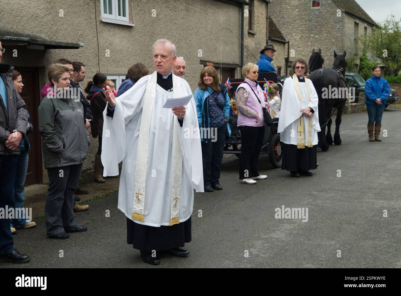 Segen der Maigirlanden aus Blumen vor der Kirche St. Mary the Virgin Village, dem Pfarrer Andrew Rycraft und dem Pfarrer Kanon Charles Masheder. (Hintergrund) Charlton-on-Otmoor, Oxfordshire, England 2014 2010er Jahre, UK HOMER SYKES Stockfoto