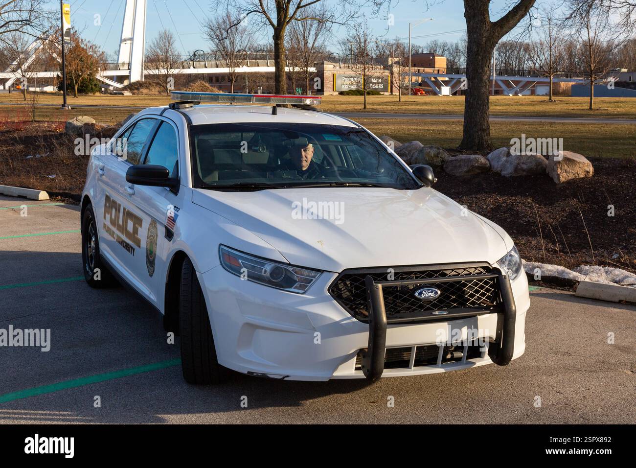 Ein Polizist der Purdue University Fort Wayne fährt einen weißen 2013er Ford Taurus Police Interceptor Patrouillenwagen auf einem Parkplatz auf dem Campus. Stockfoto