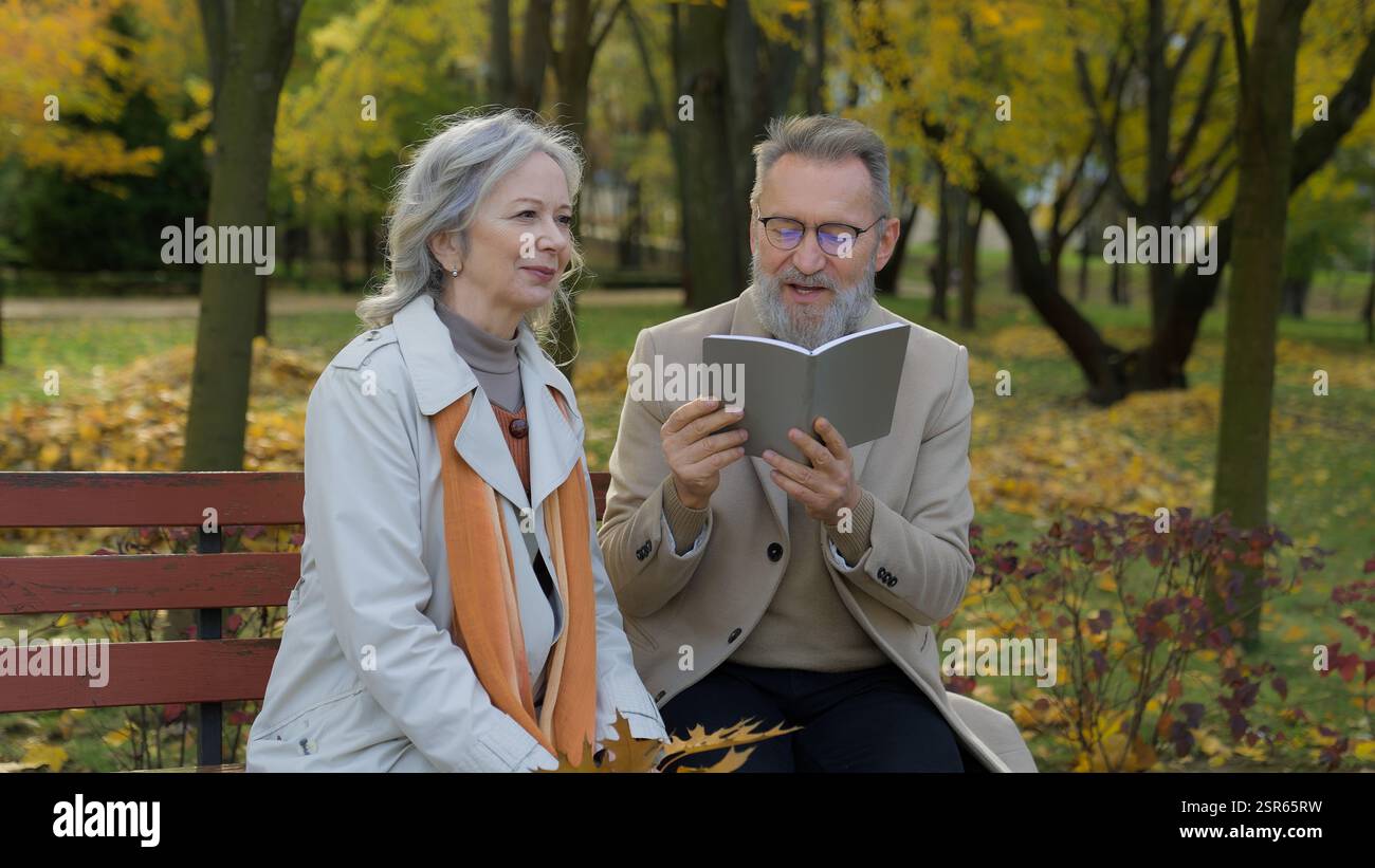 Altes Paar ältere ältere ältere Frau Mann kaukasische Familie intelligent pensionierte männliche Leserin Buch Gedicht lesen Literatur auf Bank im Park Ehemann Stockfoto