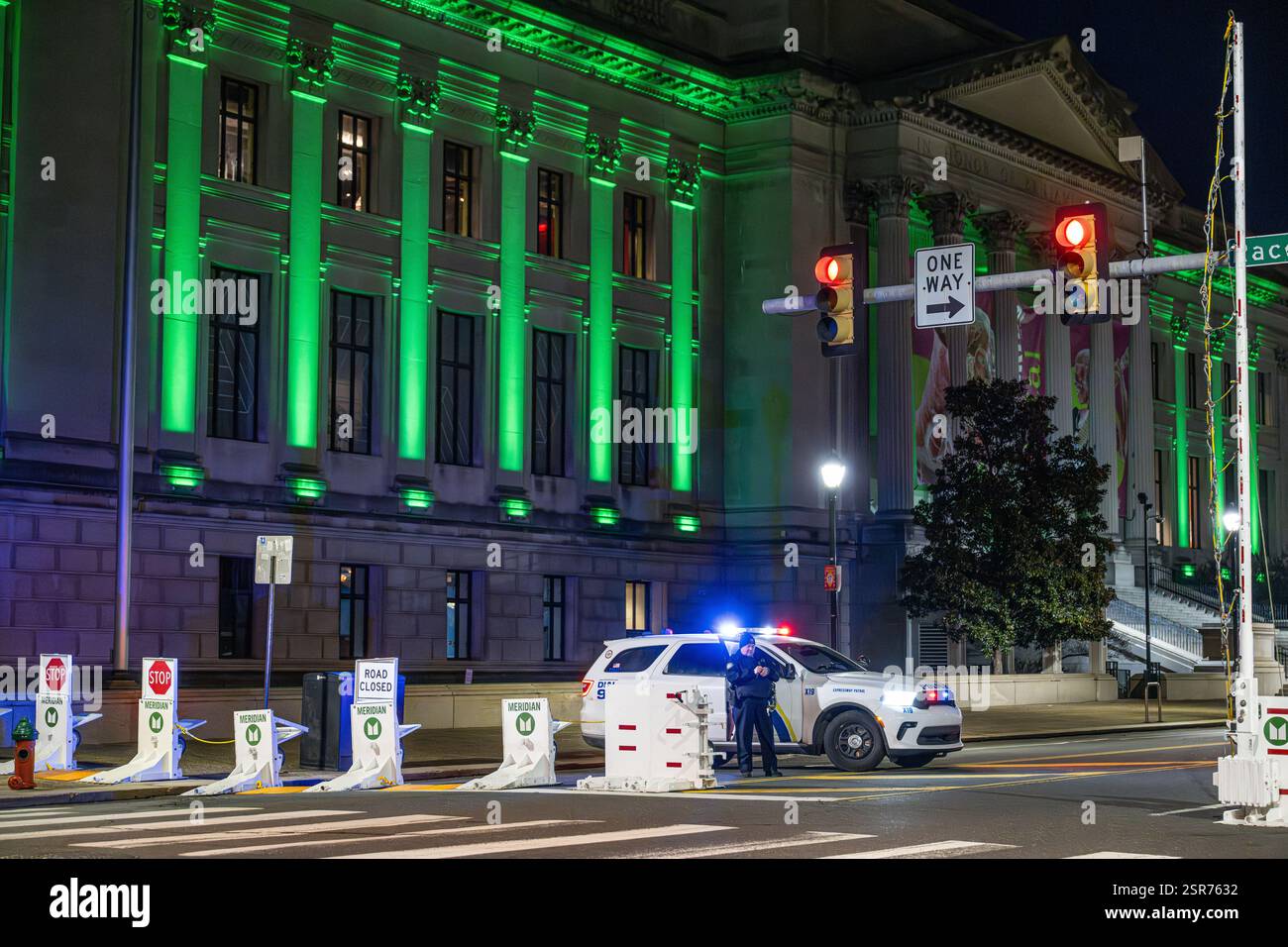 Ein Polizist aus Philadelphia errichtet Straßenbarrikaden vor der Philadelphia Eagles Super Bowl Parade - NFL Championship Team - Straßenbarrikaden für die öffentliche Sicherheit, hinter denen die Lichter der Polizei blinken Stockfoto