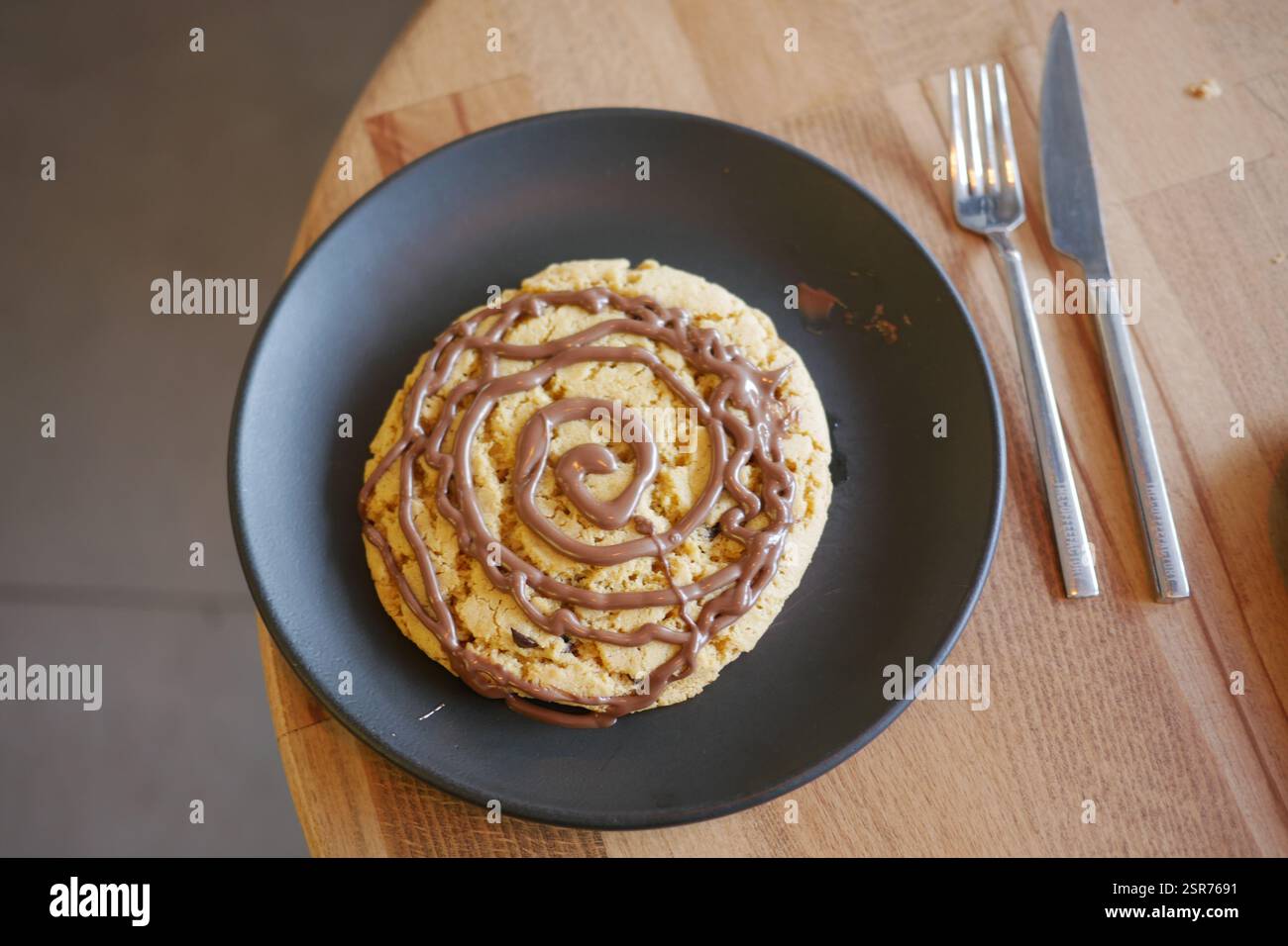 Leckeres Dessert auf einem Teller mit schwingendem Schokoladenbelag Stockfoto