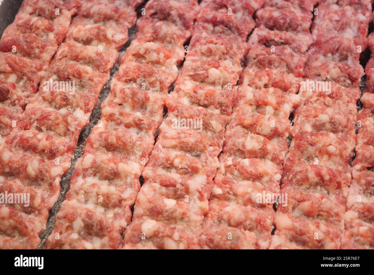 Frisch zubereitetes Hackfleisch in ordentlichen Reihen zum Kochen Stockfoto