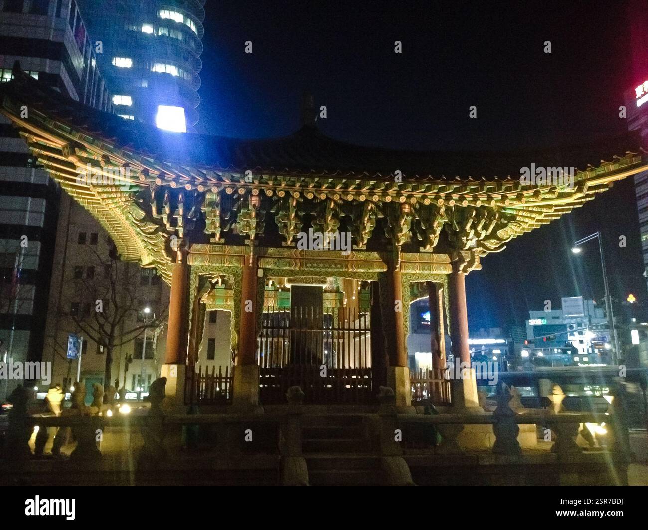 Pavillon: Beleuchtete Struktur mit kunstvollem Dach und lebhaften Farben. Traditionelle koreanische Architektur, die Schönheit und Erbe symbolisiert. Auch ein Collabori Stockfoto