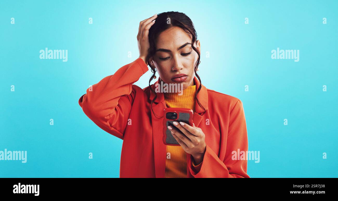 Frau, Telefon und verwirrt mit Fehlern im Studio, Stress und verlorenem Geld, um im Internet mit blauem Hintergrund zu betrügen. Mädchen, Person und traurig mit App auf dem Smartphone Stockfoto