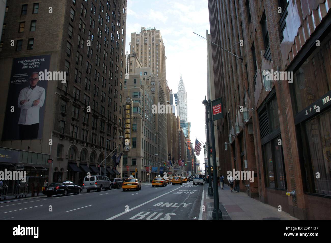 New York City quirlige Kreuzung: Gelbe Taxis bewegen sich zwischen hoch aufragenden Wolkenkratzern. Eine Szene voller urbaner Energie. Stockfoto
