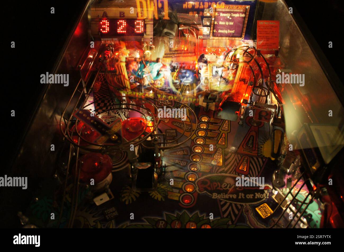 Ein Blick in eine Flippermaschine in New York, Manhattan, zeigt eine fesselnde Szene. Das beleuchtete Spielfeld mit blinkenden Lichtern und Punkteständen Stockfoto