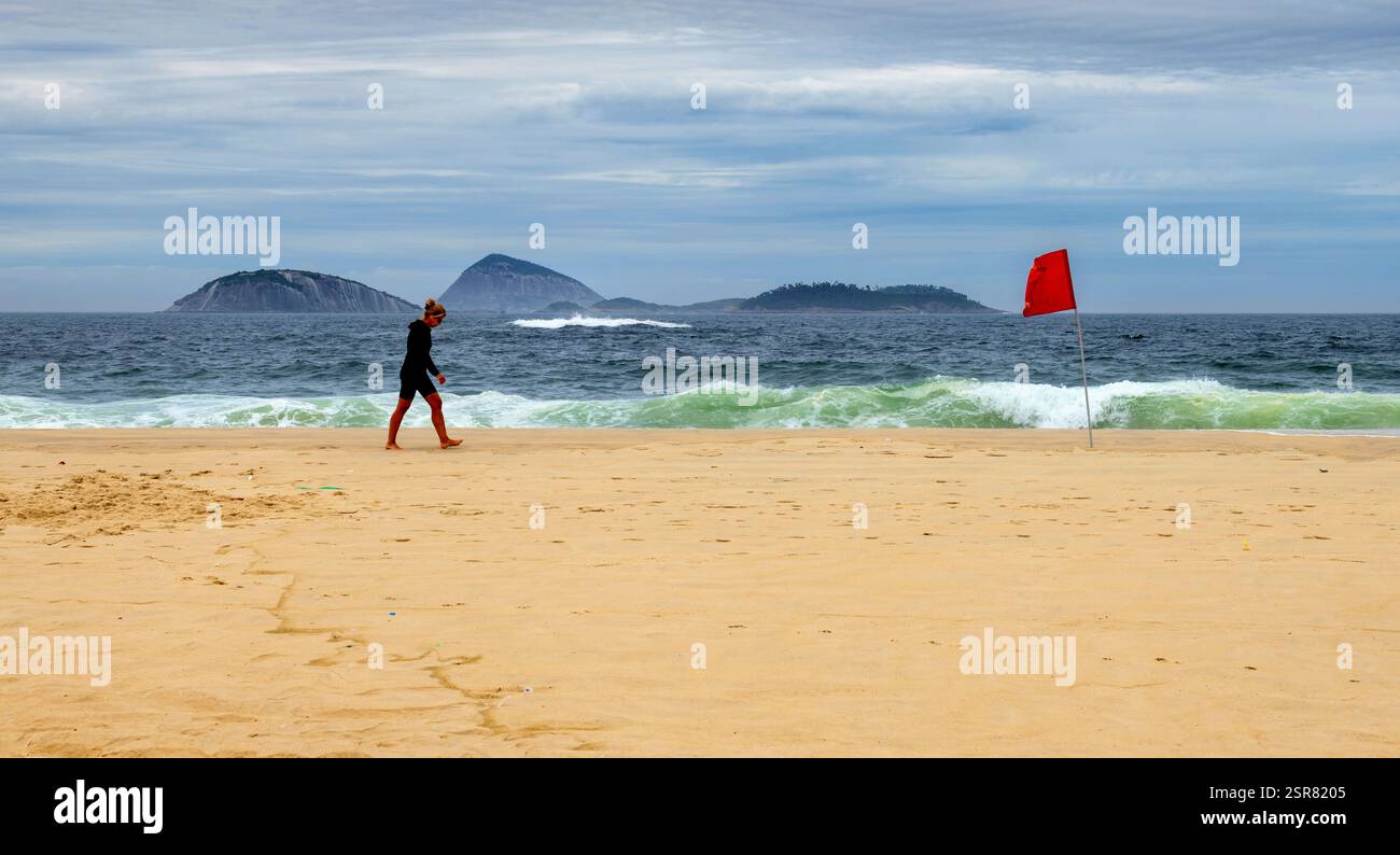 Frau, die am Strand von Ipanema in Rio de Janeiro läuft Stockfoto