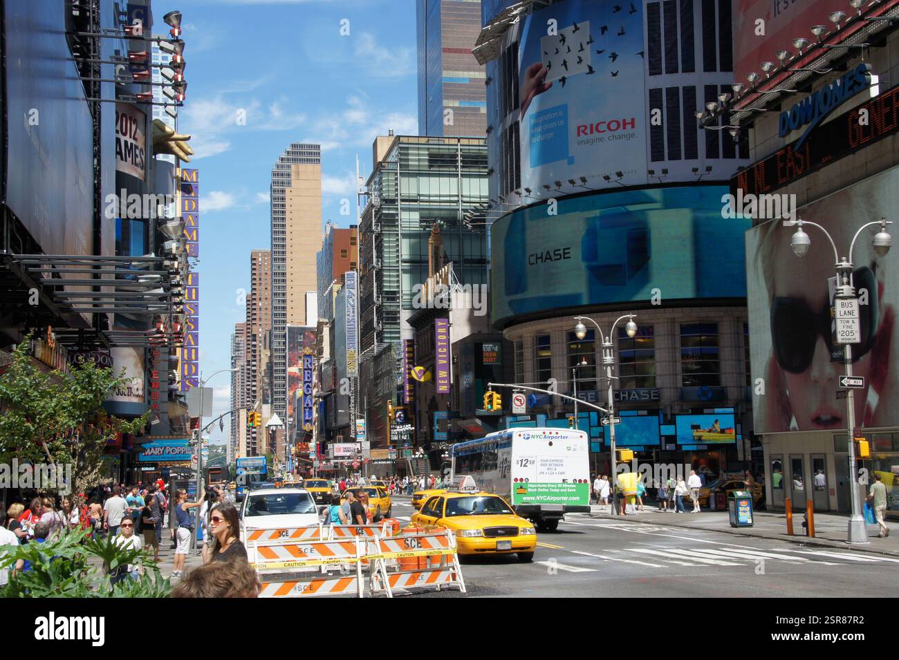 Eine Textplakette am Times Square, Manhattan, New York, zeigt Orte und Logos für Ricoh, Chase, JPMorgan Chase und Mary Poppins. Die Beschilderung ist Stockfoto