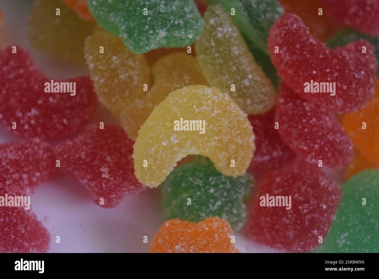 Genießen Sie dieses lebhafte Dessert mit roten Samtbröseln und bunten Gummibonbons, perfekt für Ihr süßes Verlangen und Ihre Inspiration für die Lebensmittelfotografie Stockfoto