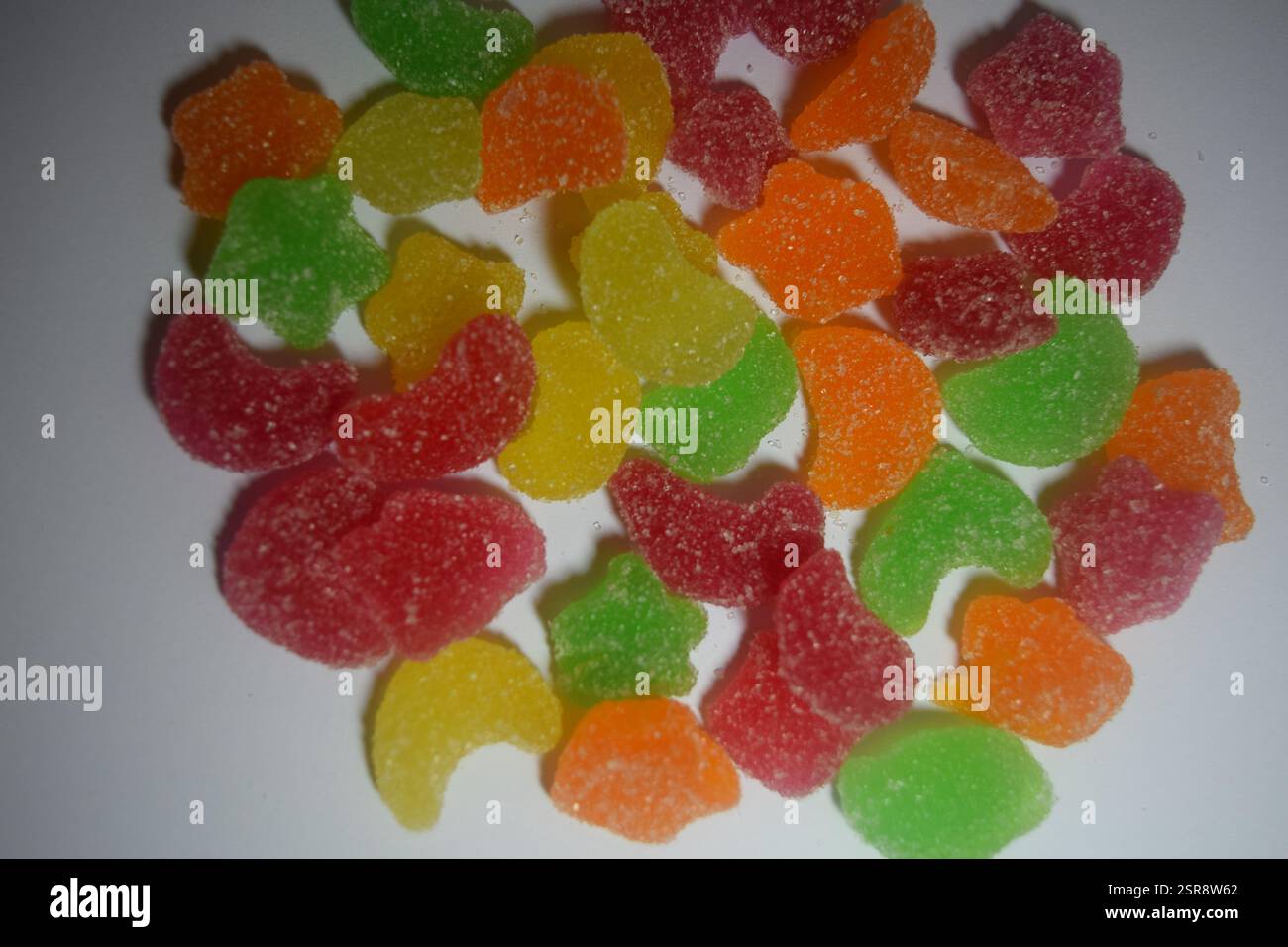 Genießen Sie dieses lebhafte Dessert mit roten Samtbröseln und bunten Gummibonbons, perfekt für Ihr süßes Verlangen und Ihre Inspiration für die Lebensmittelfotografie Stockfoto