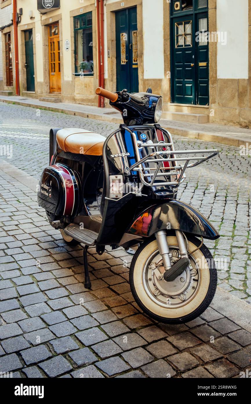 Schwarzer Vespa-Roller in einer gepflasterten Seitenstraße, Vila Nova de Gaia, Porto, Portugal Stockfoto