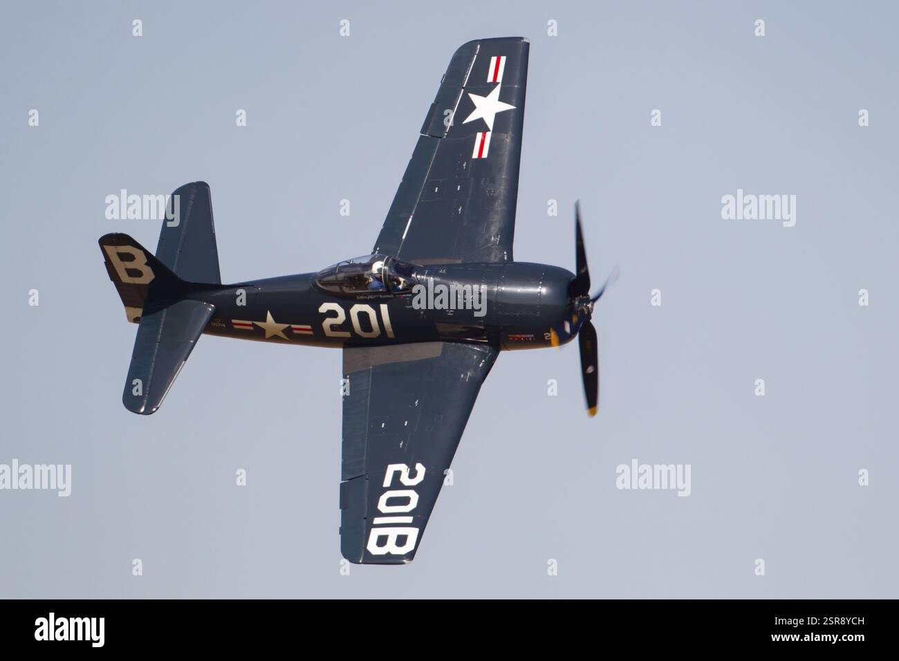 Grumman F6F Hellcat Warbird-Flugzeug in den Farben der United States Navy fliegen in einem blauen Himmel, England, Großbritannien, Europa Stockfoto