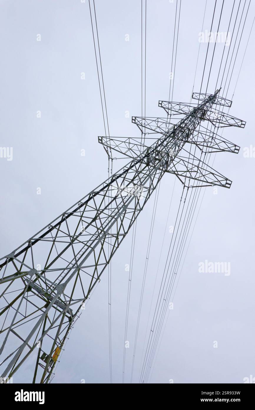 Strommast mit Drähten gegen blauen Himmel Stockfoto