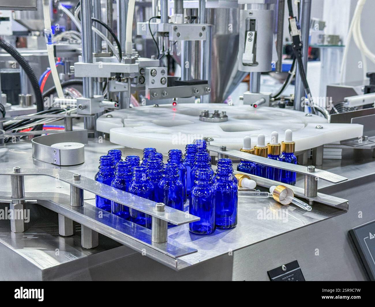 Glasflaschen in einem Förderband auf einer hochwertigen automatischen vertikalen Abfüllmaschine. In der Produktionslinie des Werks Stockfoto