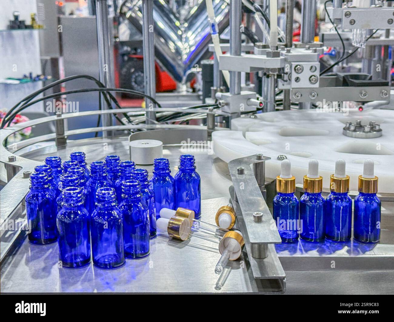 Glasflaschen in einem Förderband auf einer hochwertigen automatischen vertikalen Abfüllmaschine. In der Produktionslinie des Werks Stockfoto