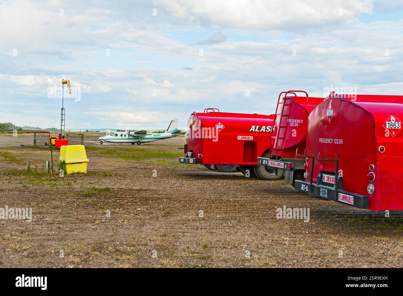 Red Aviation Fuel Trucks und eine Bundesregierung haben zweimotorige Aero Commander Flugzeuge für das Bureau of Land Management in Alaska beauftragt. Stockfoto