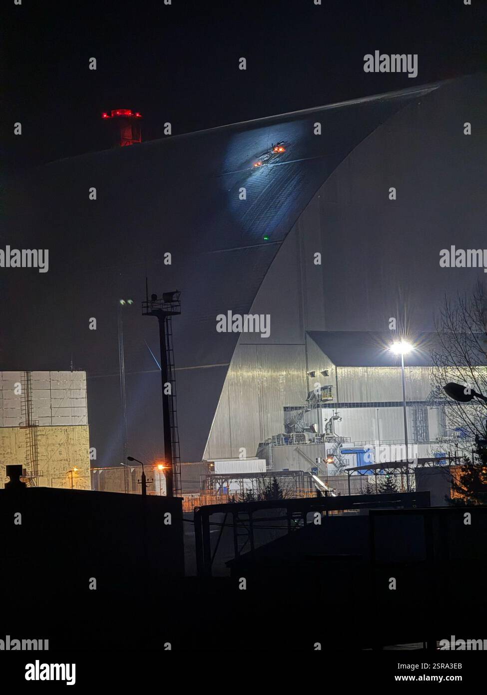 Russische Drohnenangriff auf das Kernkraftwerk Chornobyl. Nach einem Drohnenangriff am 14. Februar 2025 ist ein Brand aus dem New Safe Containment (NSC) am Standort des Kernkraftwerks Chornobyl zu sehen. Stockfoto Russische Drohnenangriff auf das Kernkraftwerk Chornobyl. Nach einem Drohnenangriff am 14. Februar 2025 ist ein Brand aus dem New Safe Containment (NSC) am Standort des Kernkraftwerks Chornobyl zu sehen. Stockfoto