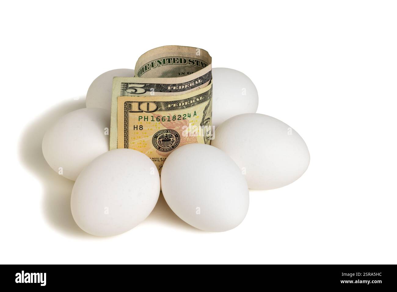 Eiergeld - Eine fünf- und zehn-Dollar-Scheine, umgeben von Eiern. Stockfoto