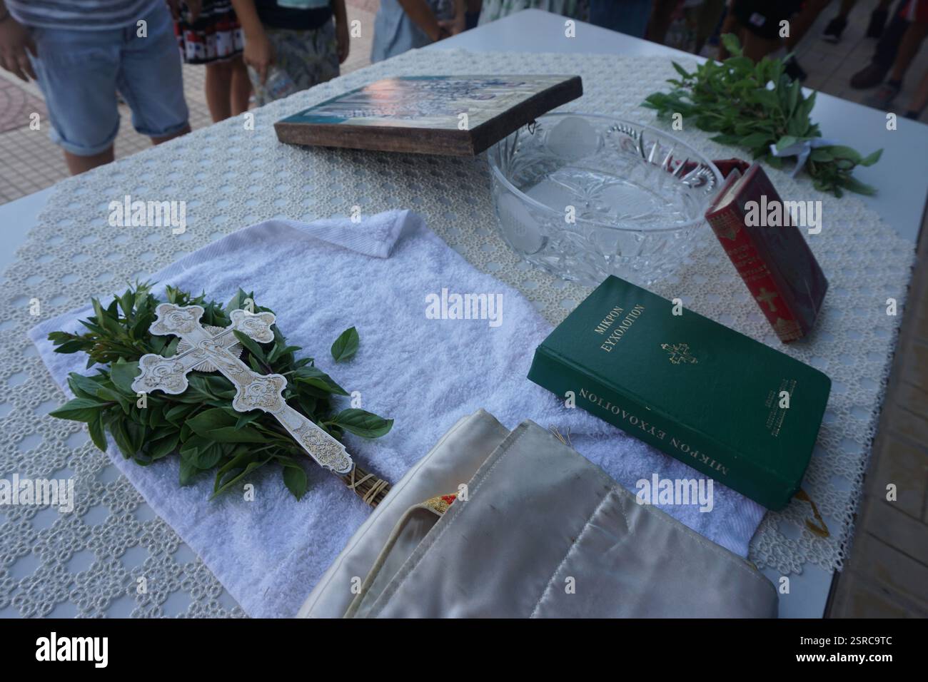 Kreta, Griechenland, 2. Juli 2015: Alles bereit auf dem Tisch für die Weihe am ersten Schultag: heiliges Wasser, kleines Wunschbuch, Basilikum Stockfoto